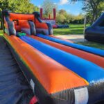 Bungee Run gonflable en location en Vendée avec pistes orange et bleue pour duel élastique